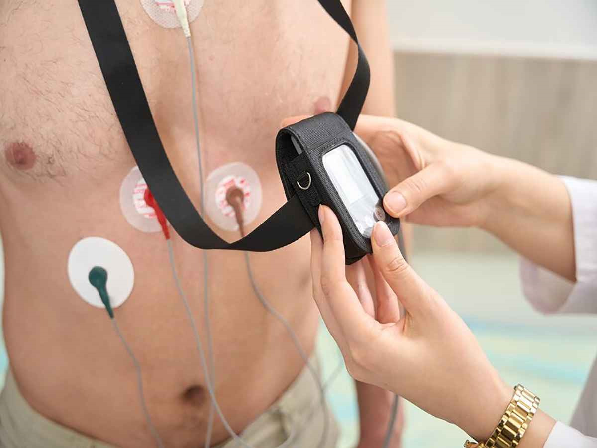 بیمار با الکترودهای هولتر و دستگاه ثبت نوار قلب ۲۴ ساعته روی گردن/کمربند